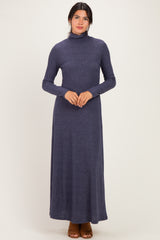 woman wearing a dark blue long sleeve turtleneck maxi dress