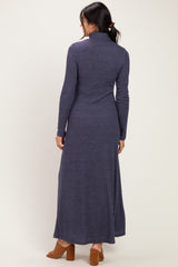 woman wearing a long navy blue turtleneck maxi dress with long sleeves and a fitted silhouette