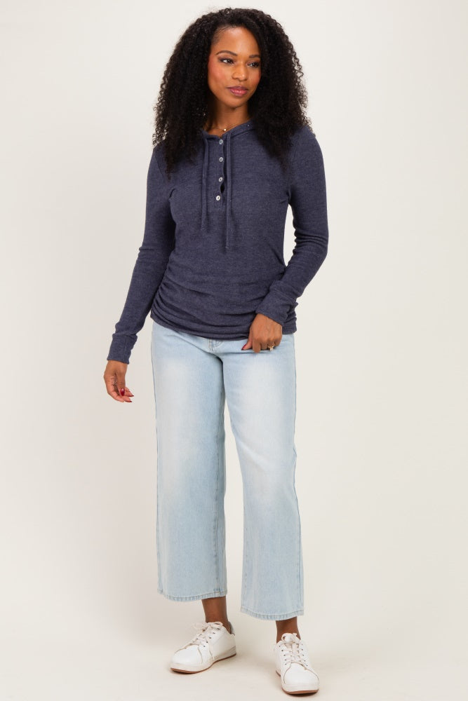 woman wearing a navy blue long sleeve henley top with buttons and light wash cropped jeans