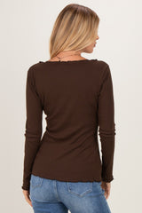 woman wearing a brown long sleeve top with a scalloped neckline and back view, paired with blue jeans