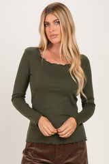 woman wearing a dark green long sleeve ribbed top with a scalloped neckline and hemline