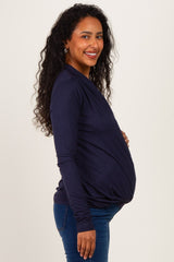 woman wearing a navy long sleeve maternity top showing her baby bump