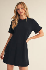 woman wearing a black short sleeve dress with ruffled edges and a relaxed fit