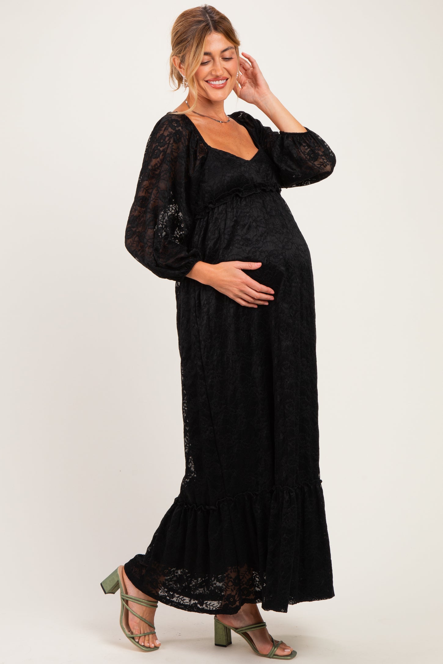 woman wearing a black lace maternity maxi dress with long sleeves and a baby bump