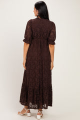 woman wearing a dark brown lace maxi dress with short puff sleeves and a tiered skirt, shown from the back