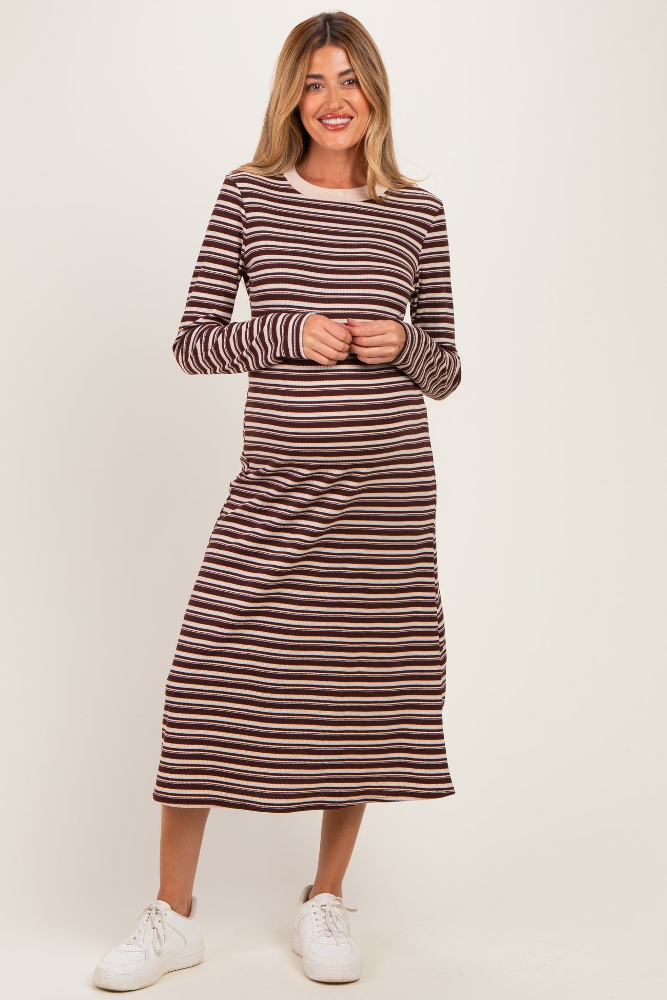 woman wearing a long sleeve brown and cream striped maternity dress with a relaxed fit