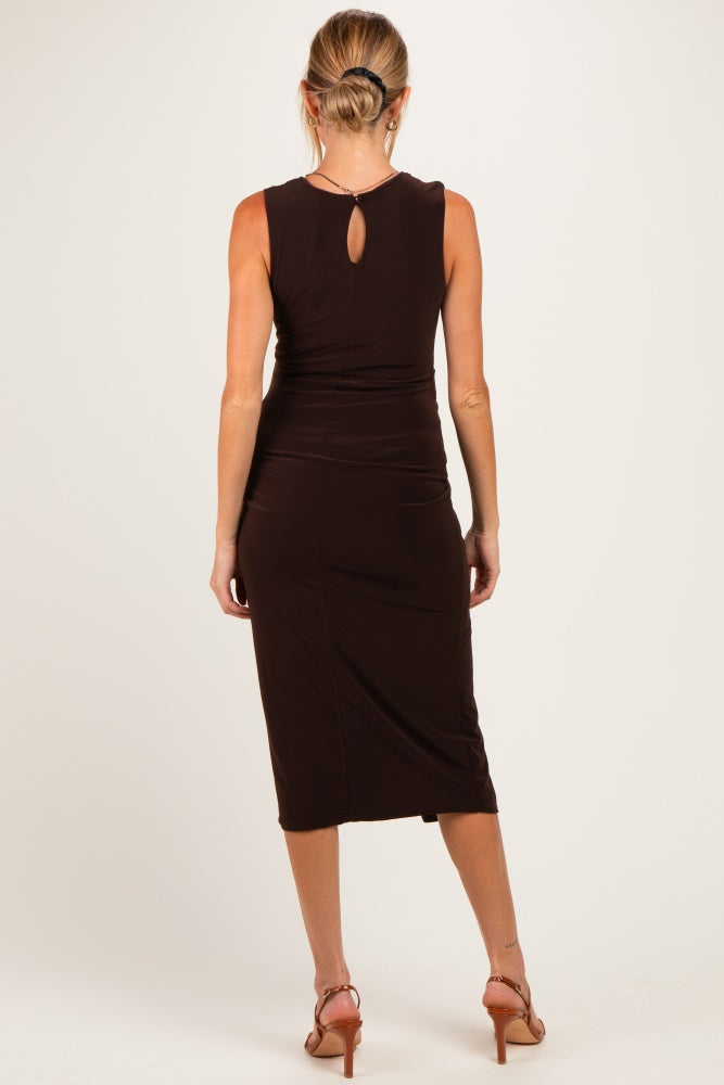 woman wearing a dark brown maternity dress with a keyhole back detail, mid-length and fitted silhouette