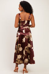 woman wearing a burgundy floral midi dress with thick straps and a fitted bodice, showing the back view