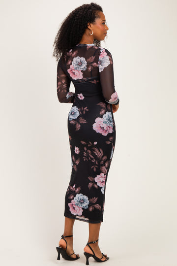 woman wearing a black floral midi dress with long sheer sleeves and a fitted silhouette