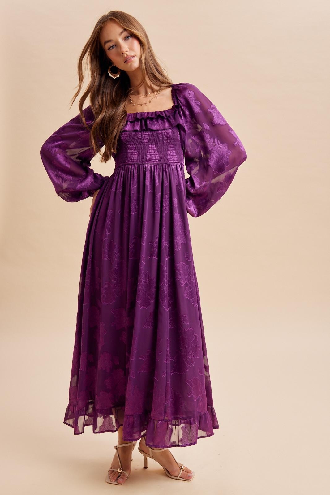 woman wearing a purple floral maxi dress with puff sleeves and a smocked bodice