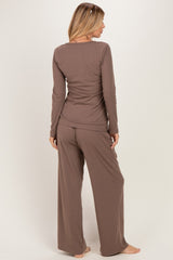 woman wearing a brown long sleeve loungewear set with loose fitting pants and top, viewed from the back