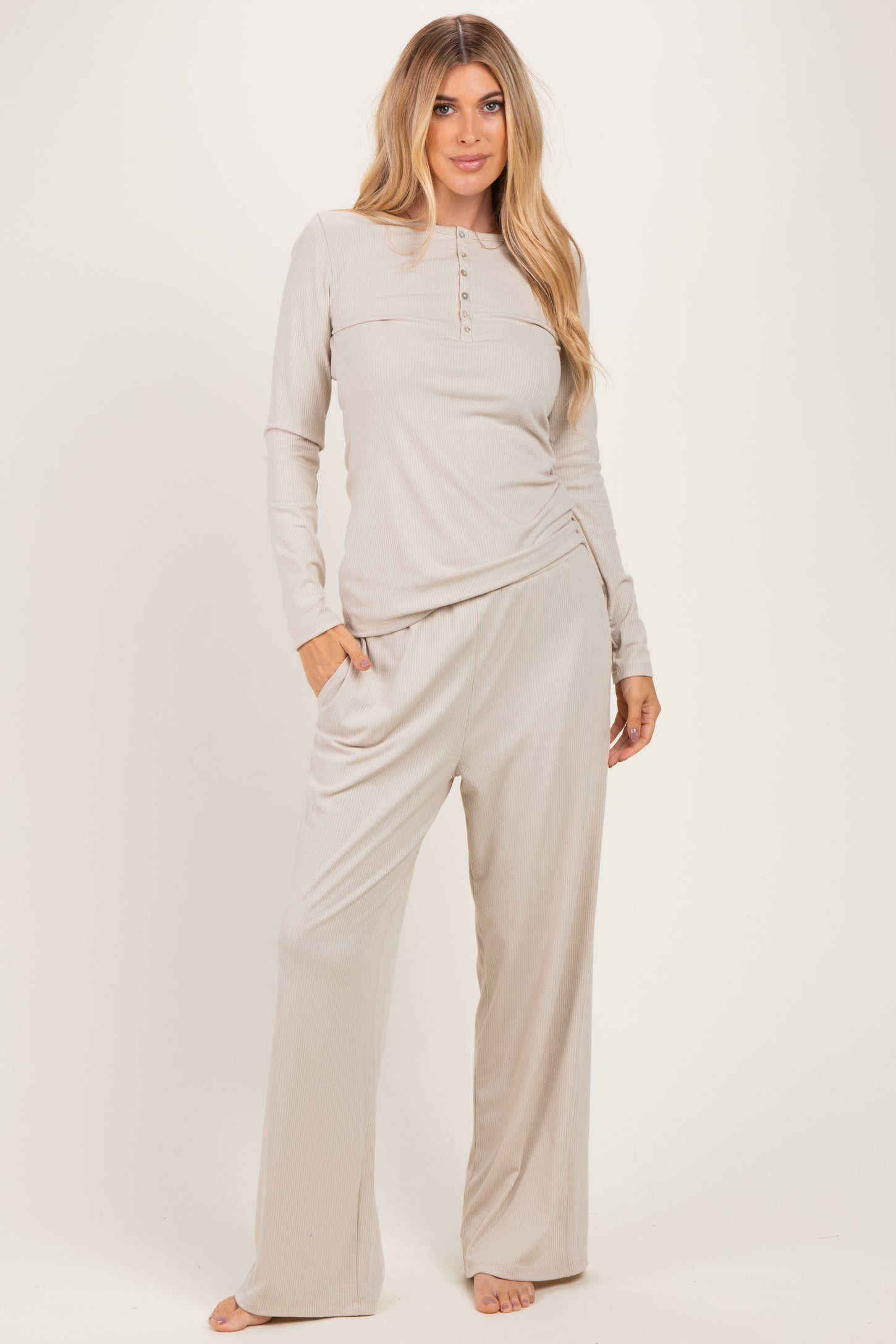 woman wearing a light gray long sleeve button-up top and matching wide-leg pants in a ribbed fabric