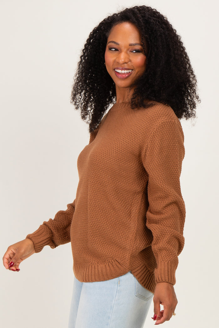 woman wearing a brown textured sweater with long sleeves and a relaxed fit, smiling and facing to the side