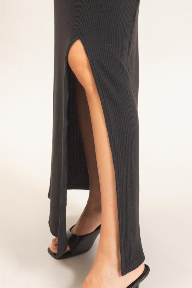 black ribbed maxi dress with thigh-high side slit, styled with black heeled sandals