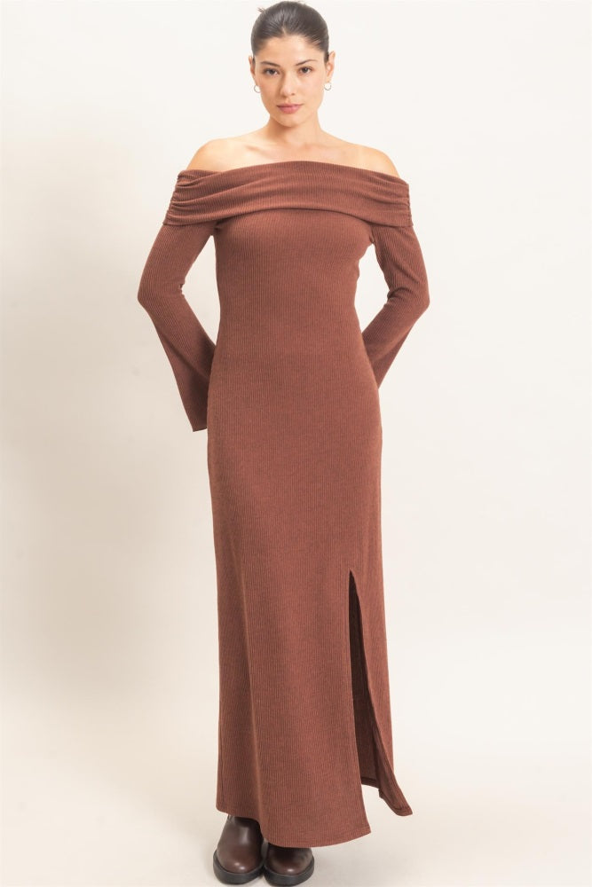 woman wearing a brown off-the-shoulder ribbed maxi dress with long sleeves and a side slit