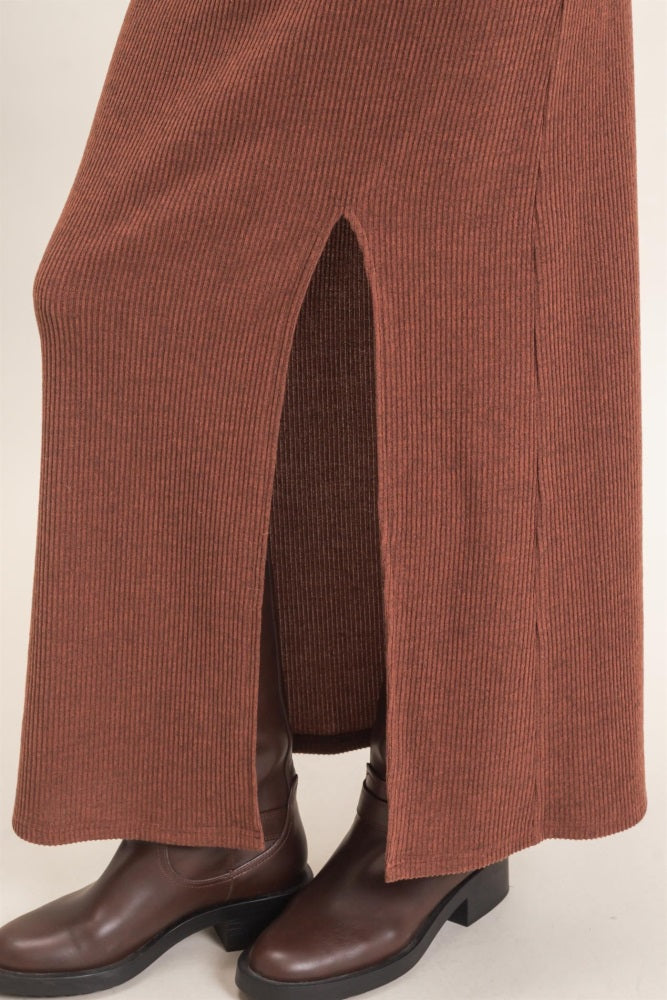 woman wearing a brown ribbed maxi skirt with side slits and brown knee-high boots