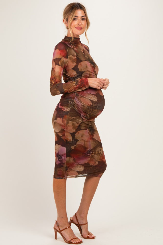 woman wearing a brown floral print maternity dress with ruching, showcasing her baby bump