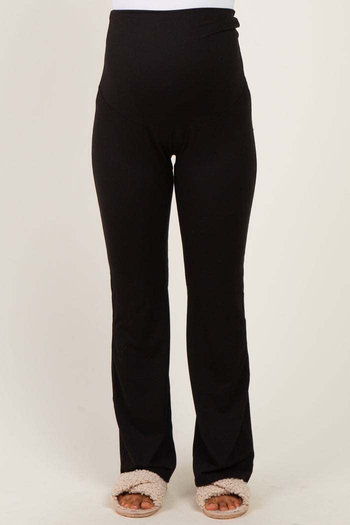 woman wearing black maternity workout leggings with a high waistband and a comfortable fit