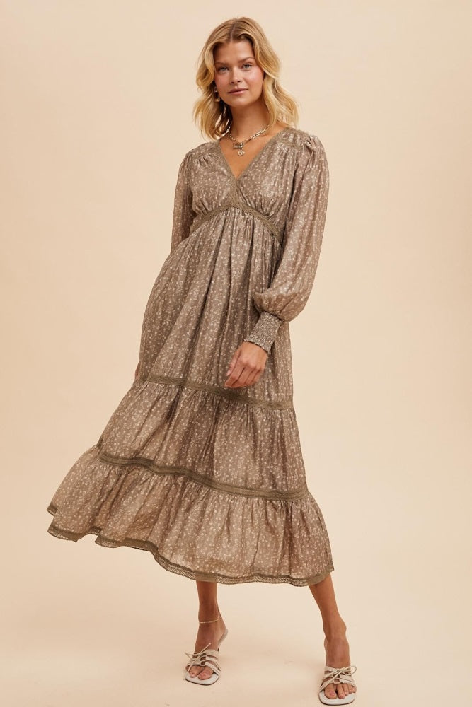 woman wearing a brown floral maxi dress with long sleeves and tiered ruffle hem
