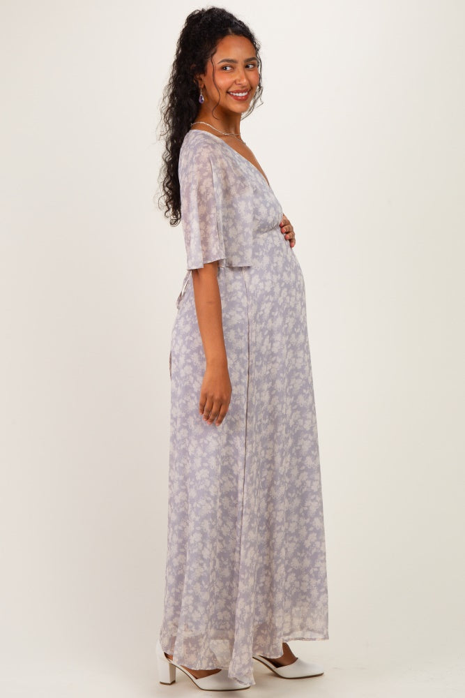 woman wearing a light purple floral maternity maxi dress and holding her baby bump
