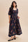 woman wearing a black floral smocked maxi dress with puff sleeves and a flowing skirt
