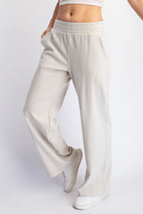 woman wearing cream wide-leg lounge pants with an elastic waistband and side pockets