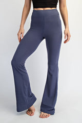 woman wearing navy blue flared yoga pants with a high waistband, standing barefoot against a white background