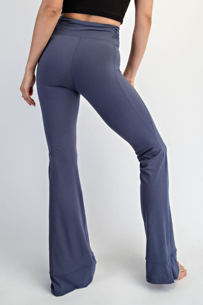 woman wearing form-fitting flared leggings in a deep blue color, showcasing a high-waisted design from the back