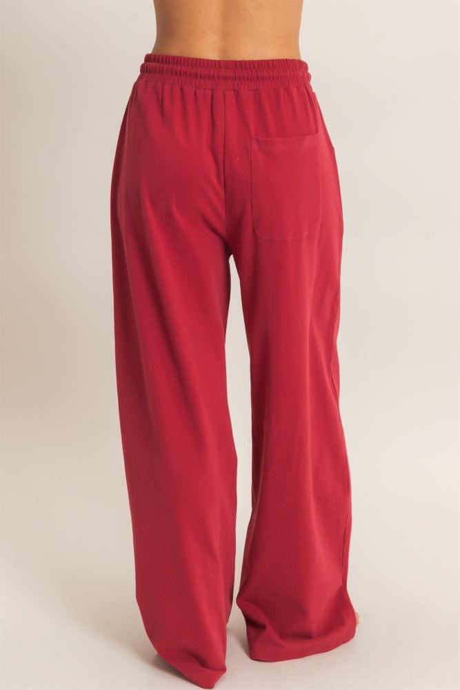 woman wearing red wide-leg lounge pants with an elastic waistband and a back pocket
