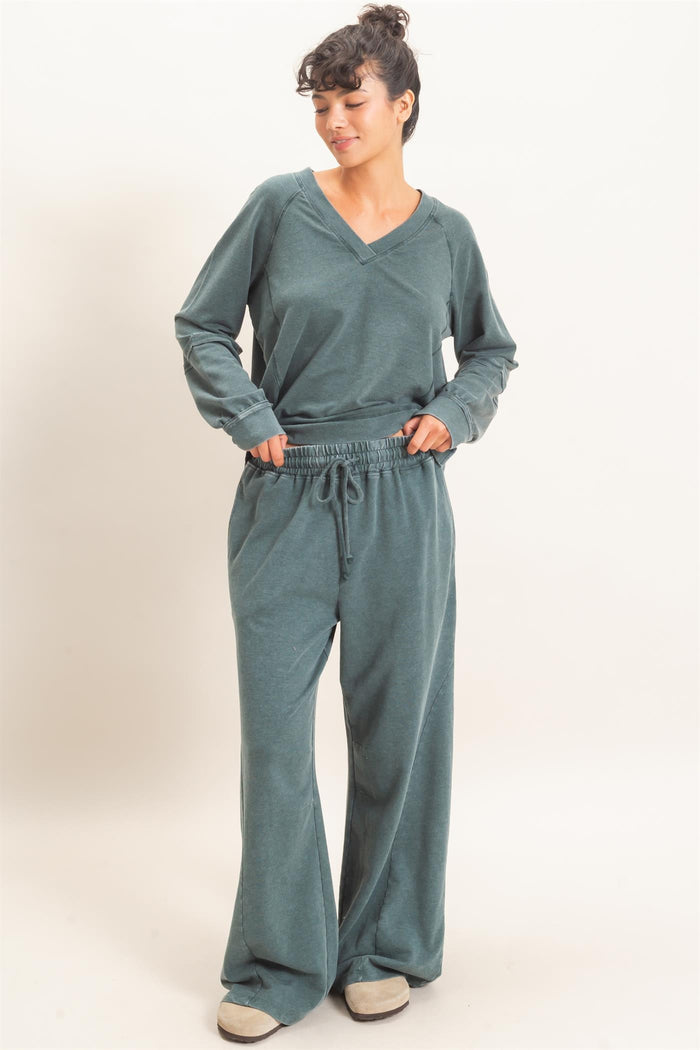 woman wearing a teal loungewear set with a v-neck long sleeve top and drawstring wide-leg pants