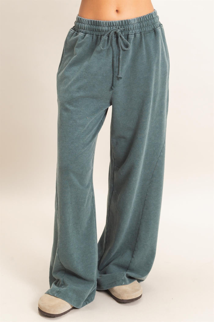 woman wearing teal relaxed fit lounge pants with an elastic waistband and drawstring detail