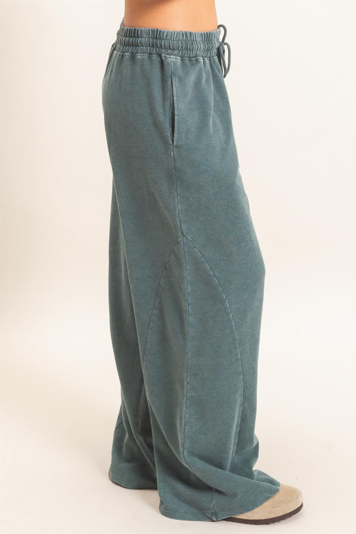 woman wearing teal wide-leg lounge pants with pockets and an elastic waistband