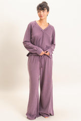woman wearing a purple long sleeve loungewear set with a v-neck and drawstring pants
