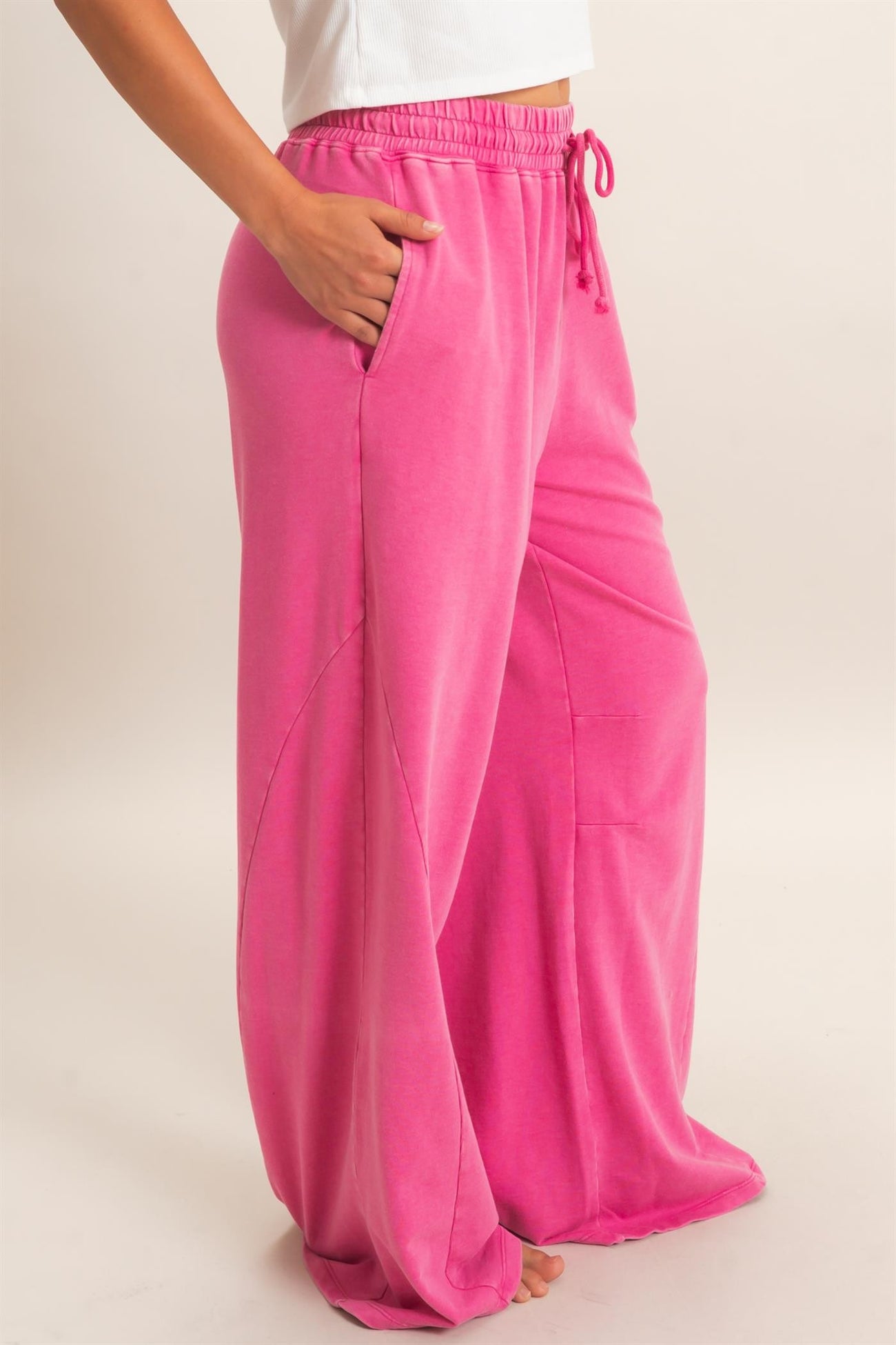 woman wearing bright pink wide-leg lounge pants with elastic waistband and pockets