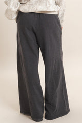 woman wearing dark gray wide-leg pants with side seam details, view from the back