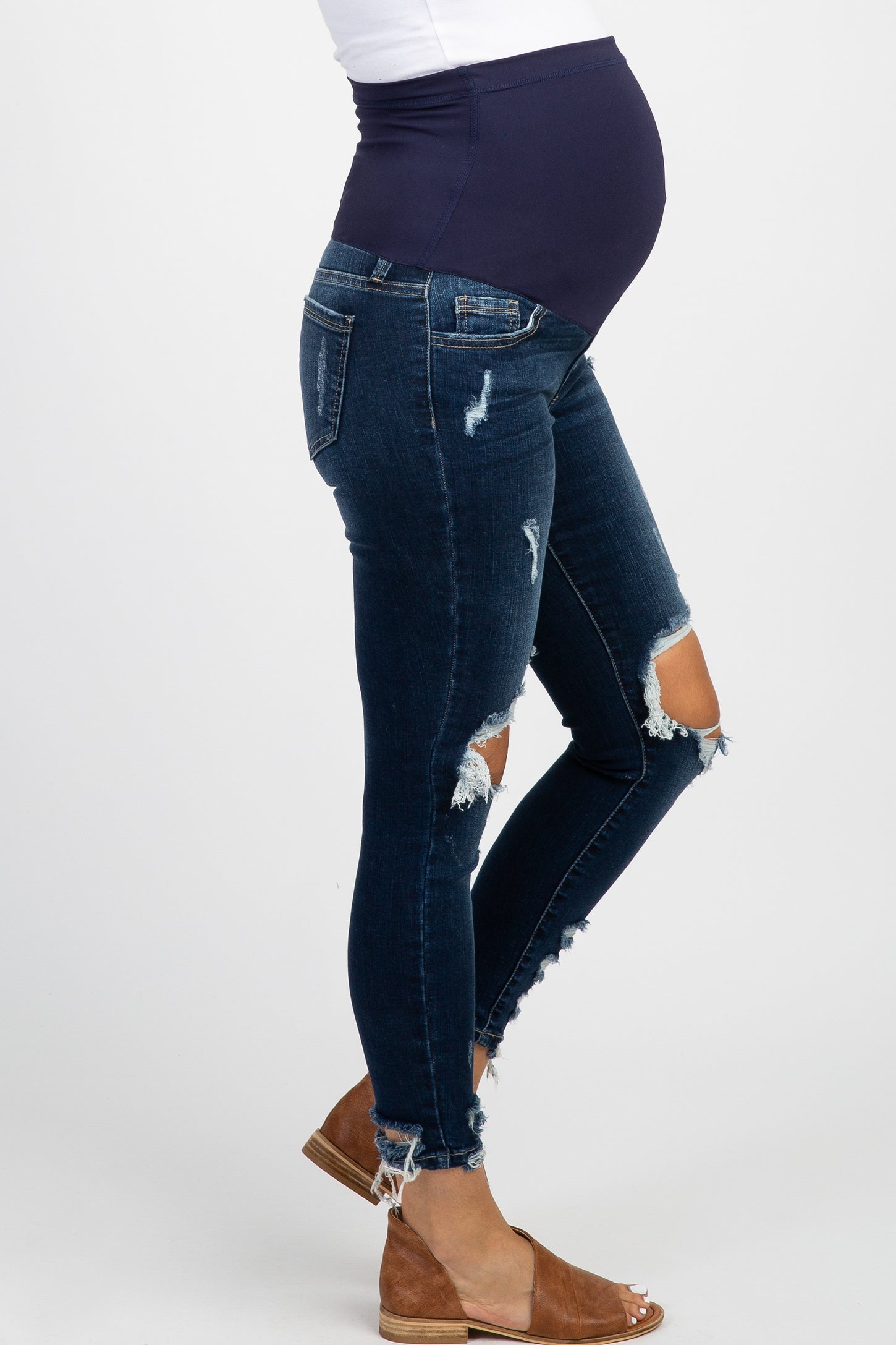 woman wearing a black maternity t-shirt with white text and distressed denim jeans, showing her baby bump