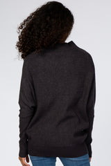 woman wearing a dark gray oversized sweater with a relaxed fit and open back, viewed from the back