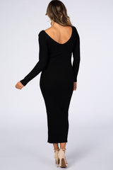 woman wearing a black ribbed long sleeve midi dress with a deep v-back