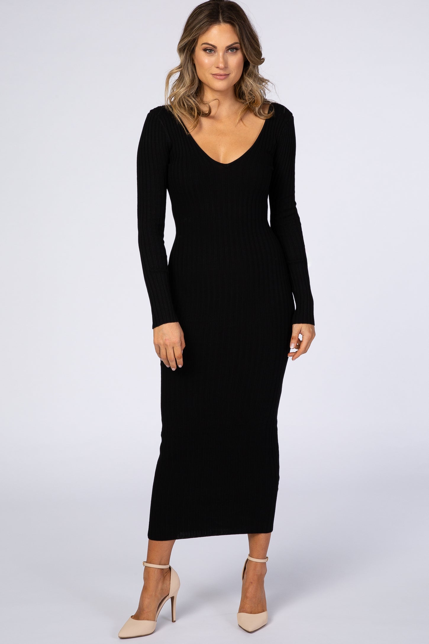 woman wearing a fitted black ribbed long sleeve maxi dress with a plunging neckline