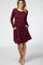 woman wearing a burgundy long sleeve dress with side pockets and a relaxed fit