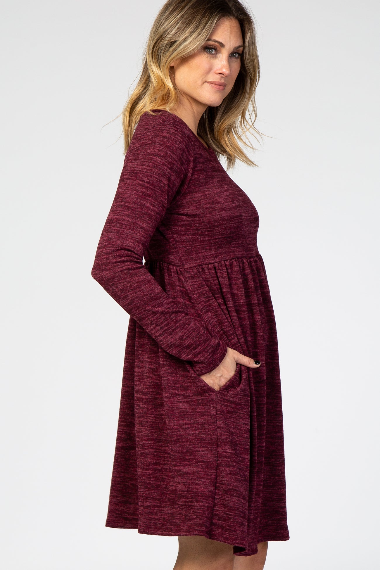 woman wearing a burgundy long sleeve dress with a flared skirt and pockets