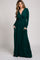 woman wearing a long sleeve deep green maxi dress with a wrap-style top and pockets