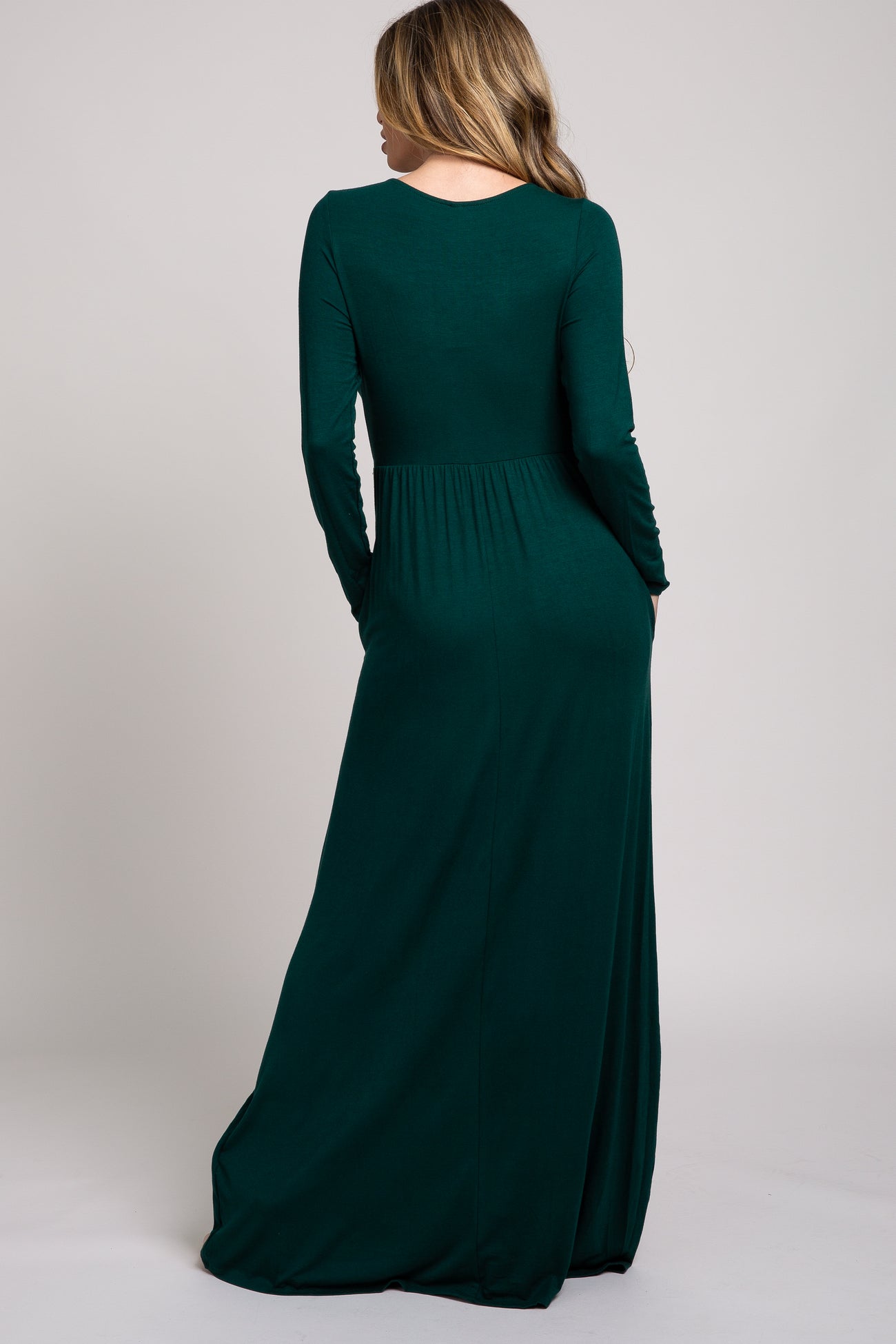 woman wearing a long sleeve dark green maxi dress viewed from the back