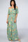 woman wearing a light green off-the-shoulder maxi dress with floral print and ruffle detailing