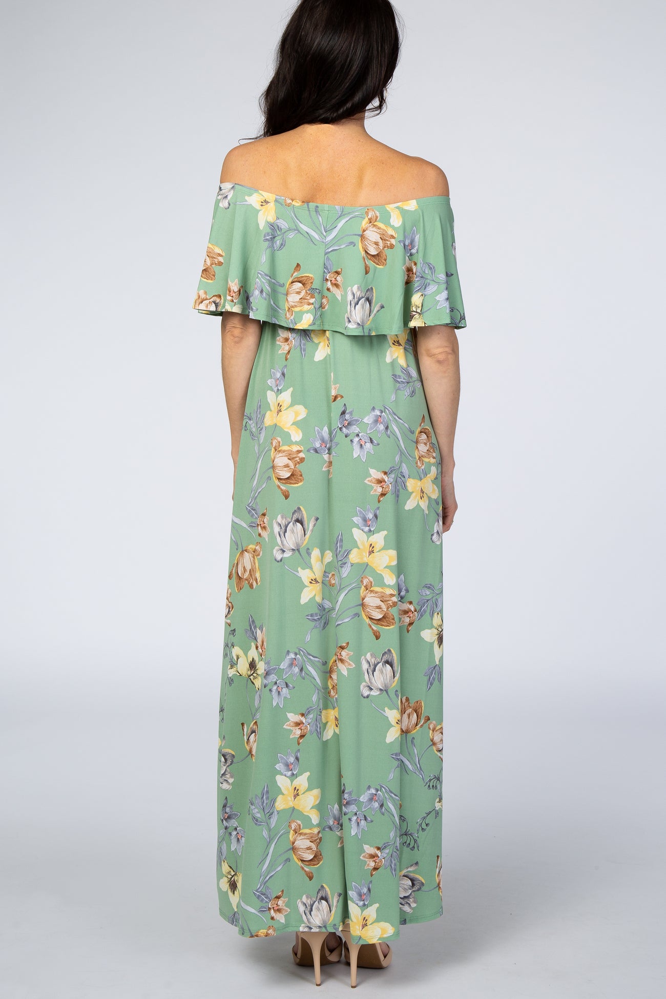 woman wearing a light green floral off-the-shoulder maxi dress, showing the back view