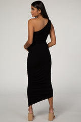woman wearing a black one-shoulder maternity dress with ruching details and a mid-length hem, showcasing a baby bump
