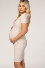 woman wearing a beige ribbed maternity dress showcasing her baby bump