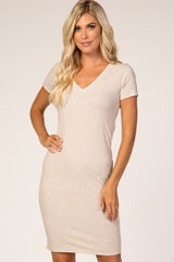 woman wearing a beige short sleeve v-neck fitted dress