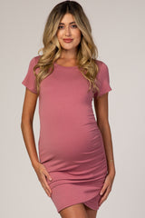 woman wearing a dusty rose short sleeve fitted maternity dress and showing her baby bump