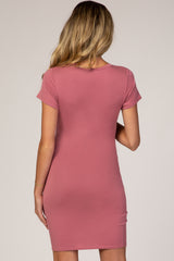 woman wearing a dusty rose short sleeve maternity dress seen from the back